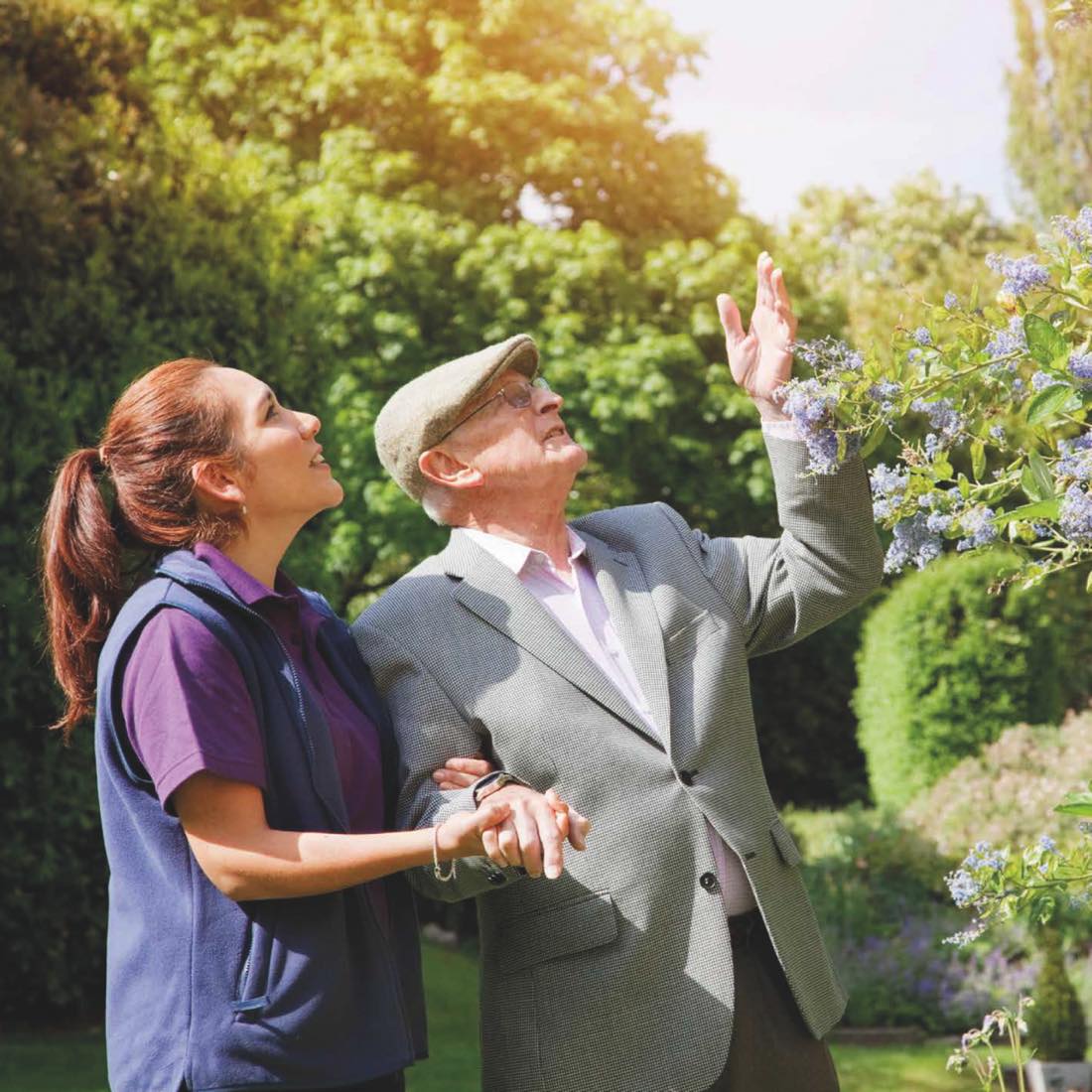 A carer and client enjoying a garden together