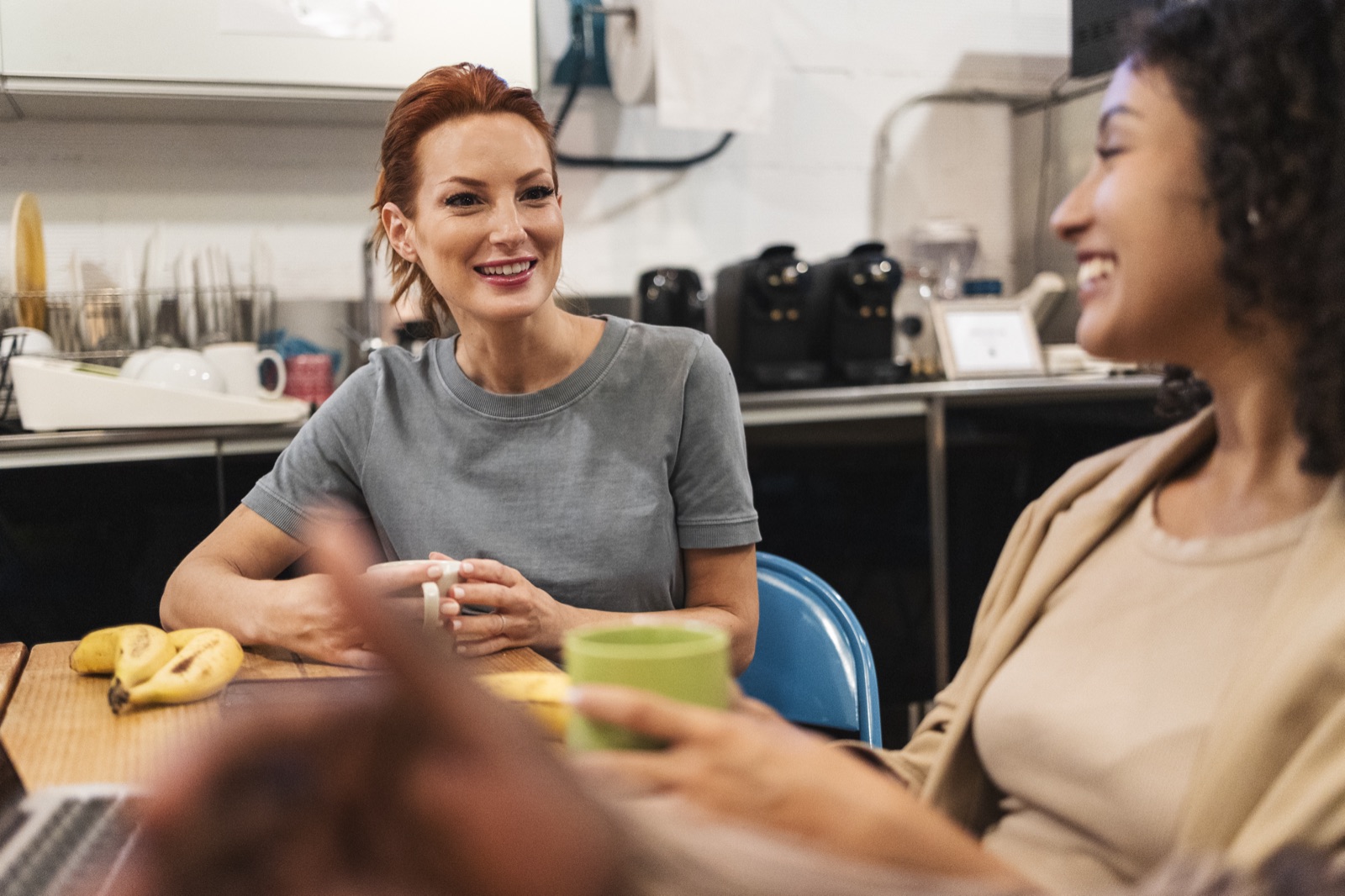 Two women chatting warmly over coffee